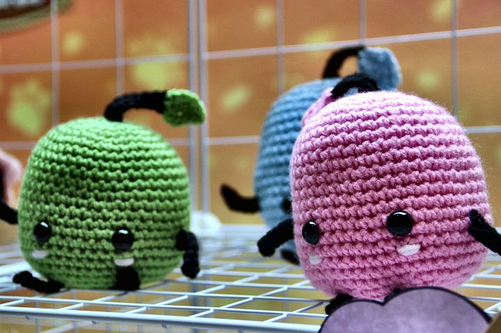 Crochet Junimo characters on a display grid